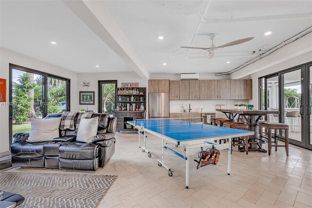 recreation room with french doors, ceiling fan, and sink