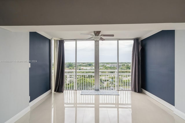 unfurnished room with tile patterned flooring, a healthy amount of sunlight, and a wall of windows