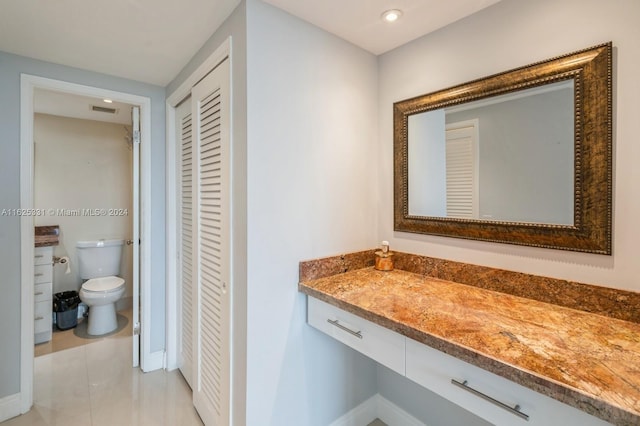 bathroom with vanity, toilet, and tile patterned flooring