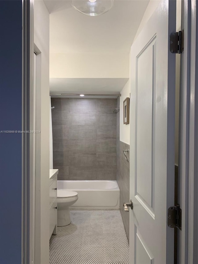 full bathroom featuring tile patterned floors, vanity, tiled shower / bath, and toilet