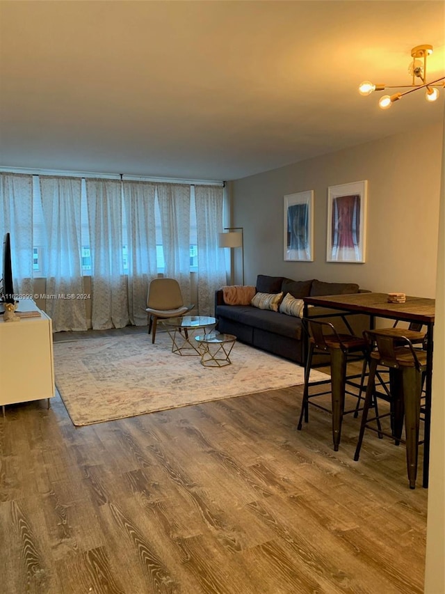 living room with hardwood / wood-style floors and an inviting chandelier