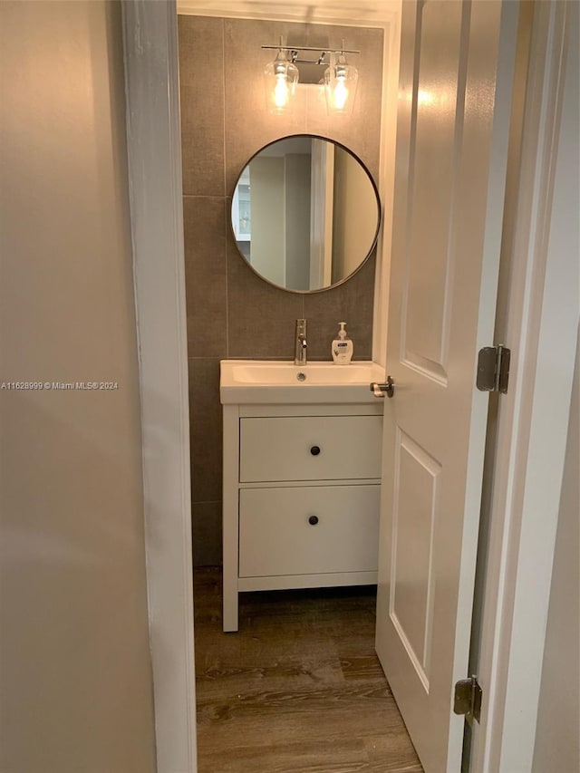 bathroom featuring vanity, hardwood / wood-style floors, and tile walls