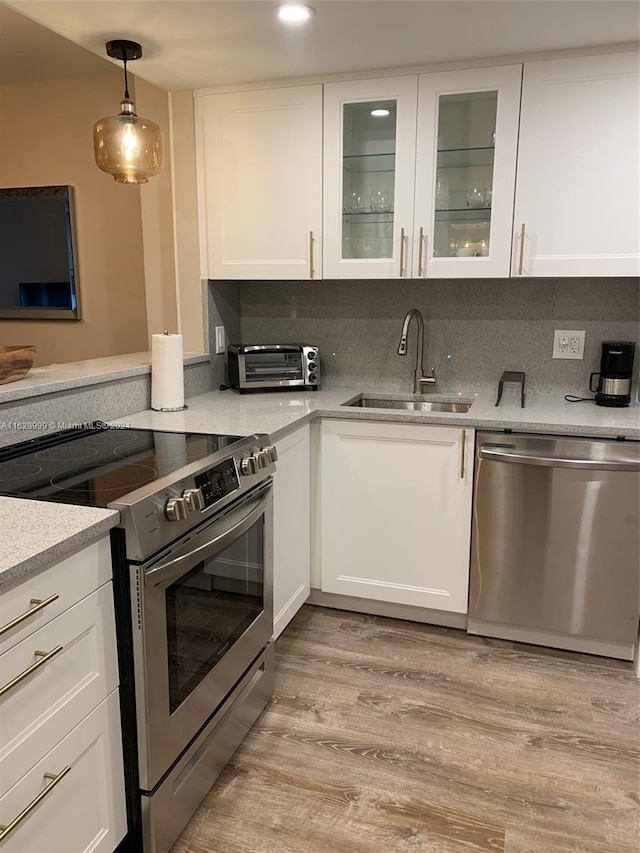 kitchen featuring decorative backsplash, light hardwood / wood-style flooring, stainless steel appliances, and white cabinetry