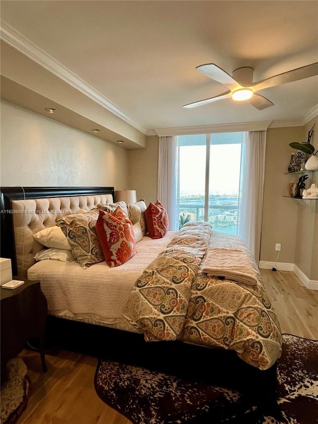 bedroom featuring ceiling fan, crown molding, and light hardwood / wood-style flooring