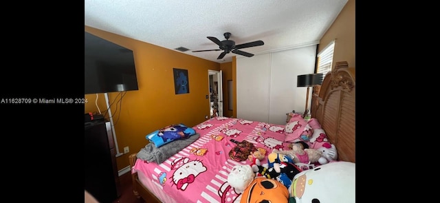 bedroom with ceiling fan and a textured ceiling