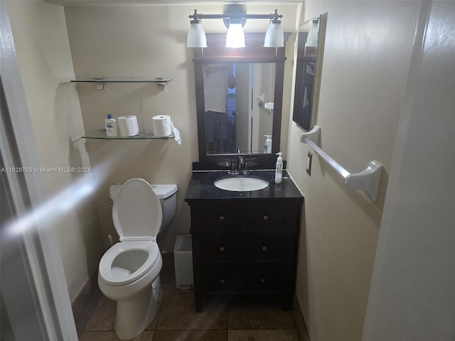 bathroom featuring toilet, vanity, and tile patterned flooring