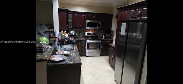 kitchen with appliances with stainless steel finishes, decorative backsplash, dark stone counters, ornamental molding, and sink