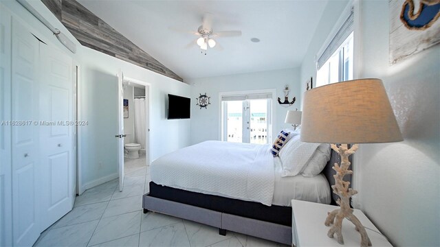 tiled bedroom with ceiling fan, vaulted ceiling, and ensuite bathroom