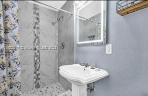 bathroom with sink and tiled shower