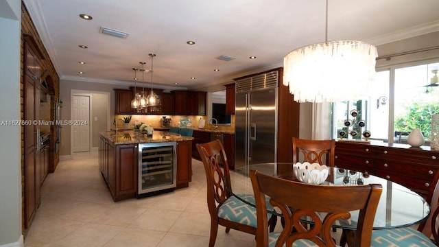 tiled dining room with wine cooler, sink, crown molding, and an inviting chandelier