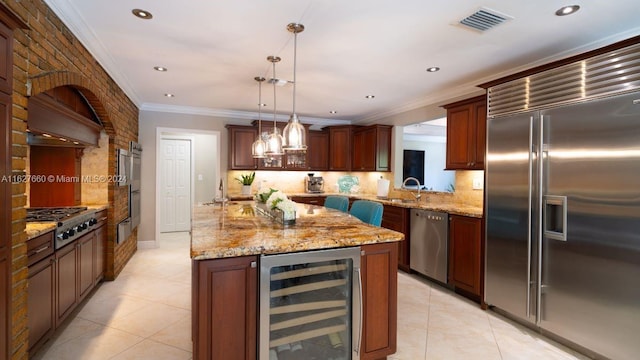 kitchen with pendant lighting, decorative backsplash, beverage cooler, and appliances with stainless steel finishes