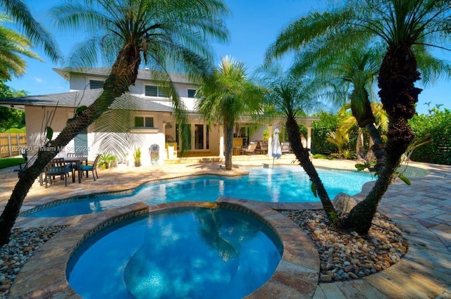 view of swimming pool with a patio area and an in ground hot tub