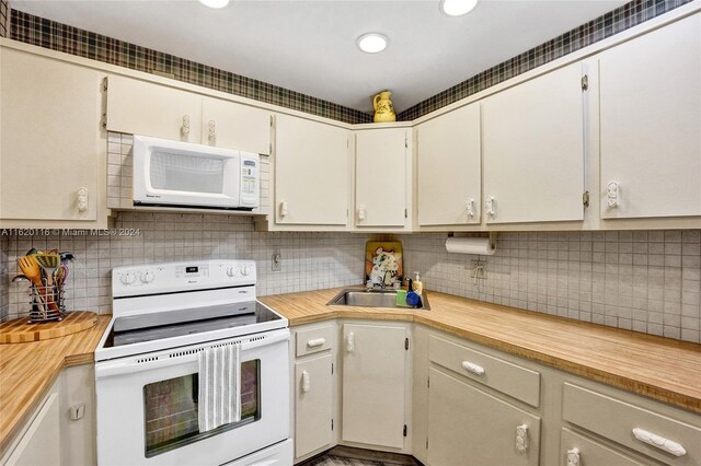 kitchen featuring sink, tasteful backsplash, and white appliances