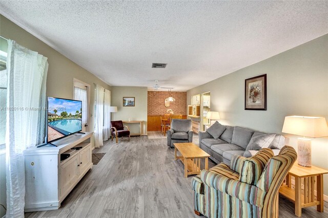 living room featuring light hardwood / wood-style floors and a textured ceiling