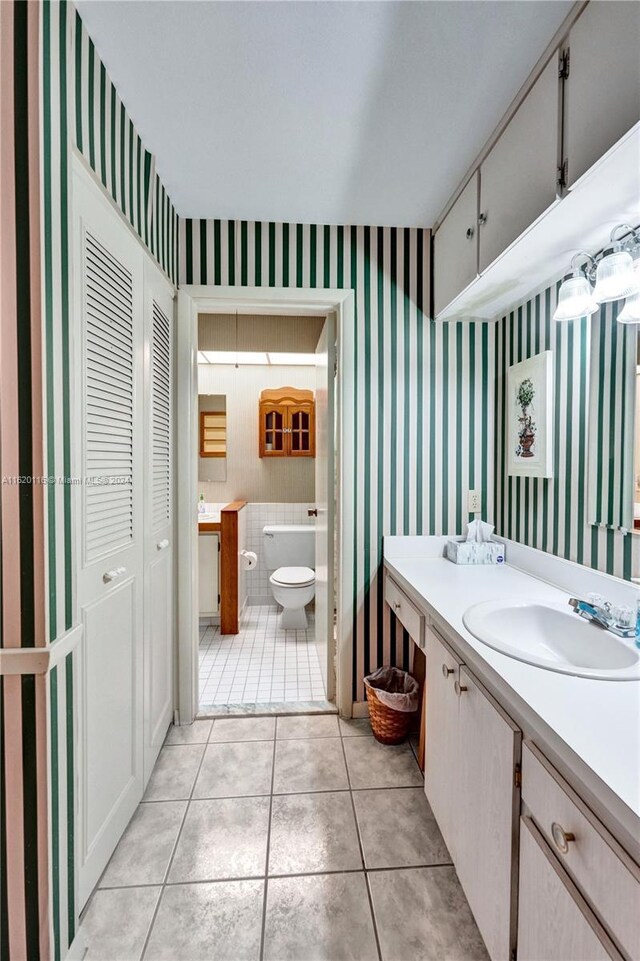 bathroom with vanity, toilet, and tile patterned flooring