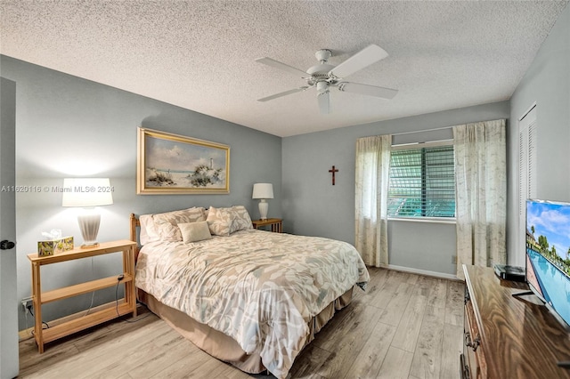 bedroom with light hardwood / wood-style flooring, a closet, a textured ceiling, and ceiling fan