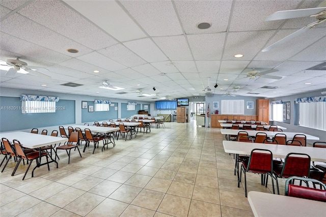 tiled dining room with a drop ceiling and ceiling fan