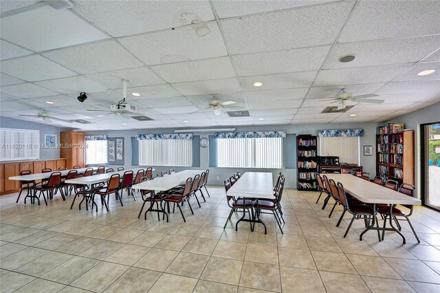 tiled dining space featuring a paneled ceiling and ceiling fan