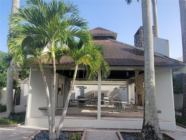 7101 SW 67th Ave Unit 1, South Miami, FL 33143 - back of house featuring stucco siding, a chimney, and a shingled roof