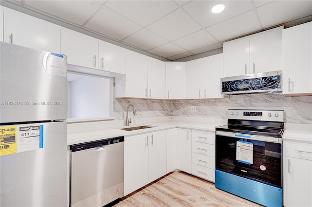 kitchen with sink, white cabinets, backsplash, and appliances with stainless steel finishes