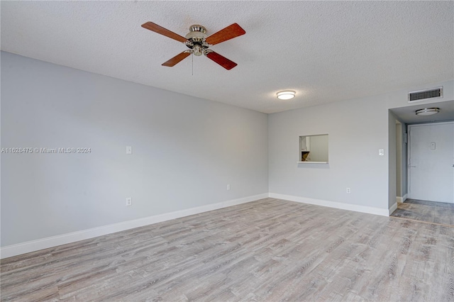 spare room with ceiling fan, a textured ceiling, and wood-type flooring