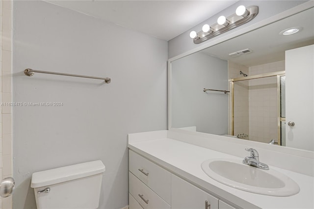 bathroom with toilet, a shower with door, and vanity