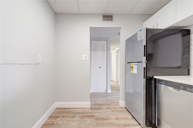 kitchen with appliances with stainless steel finishes, light hardwood / wood-style floors, and white cabinets