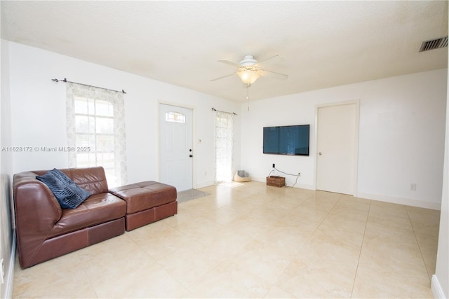 living room with a textured ceiling and ceiling fan