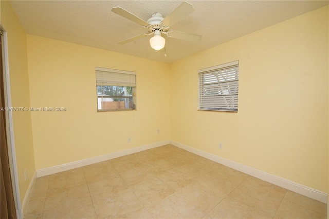 tiled spare room with a textured ceiling and ceiling fan