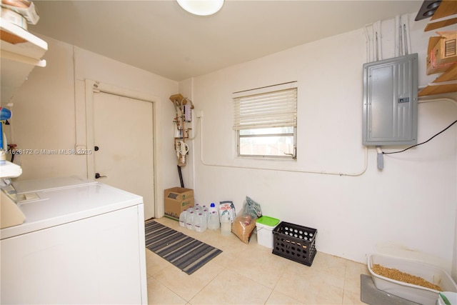 clothes washing area featuring light tile patterned floors, electric panel, and washing machine and clothes dryer