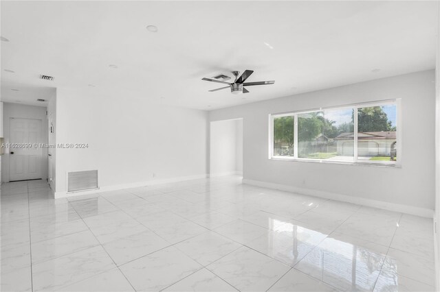 551 NW 42nd Ave, Coconut Creek, FL 33066 - spare room with visible vents, baseboards, marble finish floor, and a ceiling fan