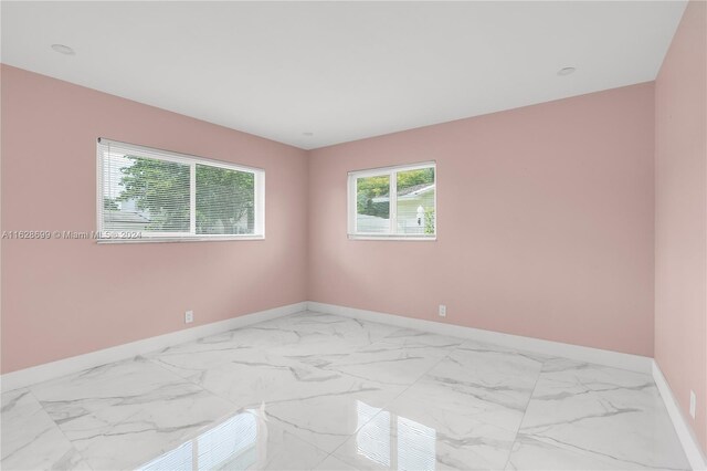 551 NW 42nd Ave, Coconut Creek, FL 33066 - empty room with marble finish floor and baseboards