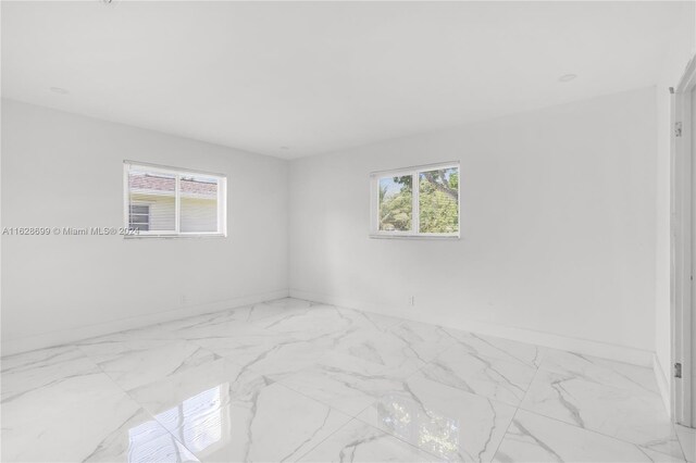 551 NW 42nd Ave, Coconut Creek, FL 33066 - empty room with baseboards and marble finish floor