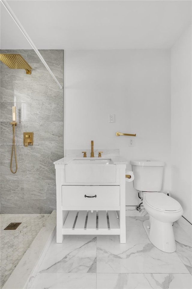 bathroom with vanity, toilet, and tiled shower