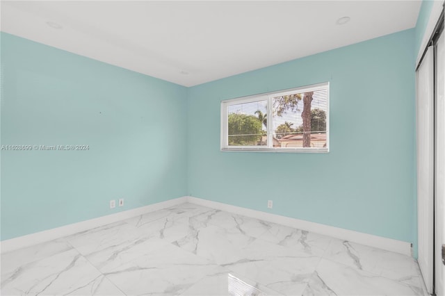 551 NW 42nd Ave, Coconut Creek, FL 33066 - spare room featuring baseboards and marble finish floor