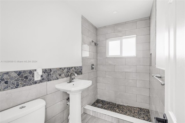 551 NW 42nd Ave, Coconut Creek, FL 33066 - bathroom with toilet, tile walls, wainscoting, and a shower stall