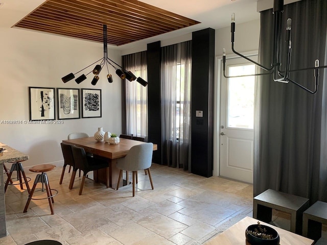 dining room with baseboards and stone tile floors