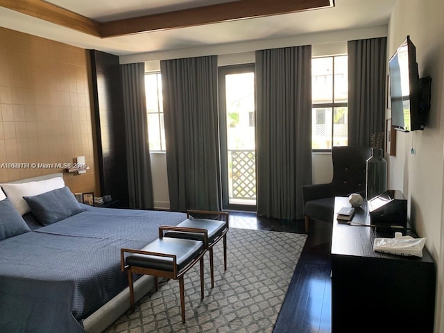 bedroom featuring wood finished floors and multiple windows