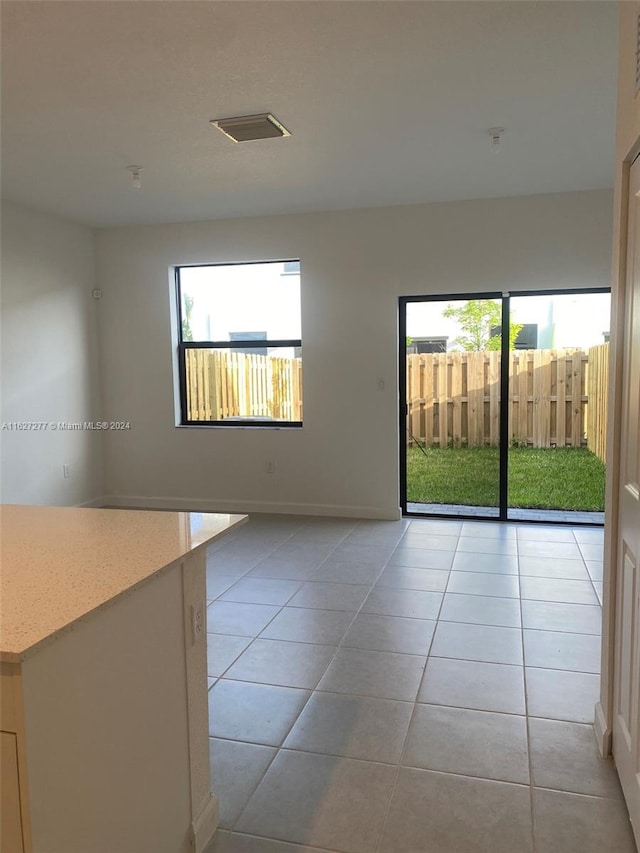 tiled spare room with a healthy amount of sunlight