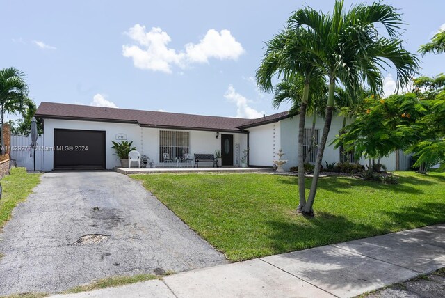 single story home featuring a garage and a front yard