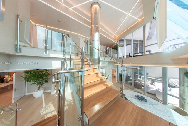 staircase with hardwood / wood-style floors and a wealth of natural light