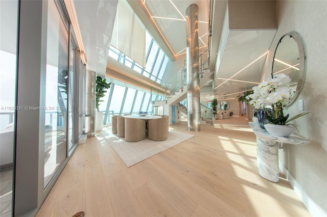 interior space with a high ceiling, a skylight, and hardwood / wood-style floors