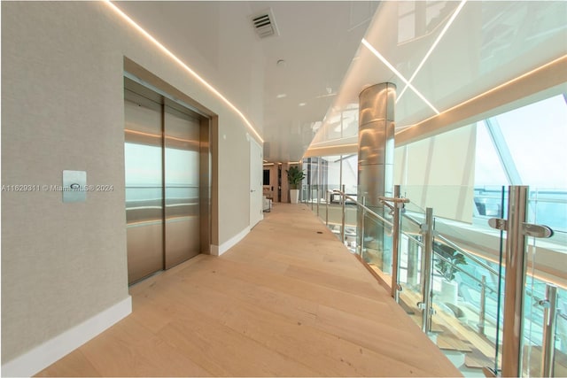 hallway with elevator and hardwood / wood-style flooring