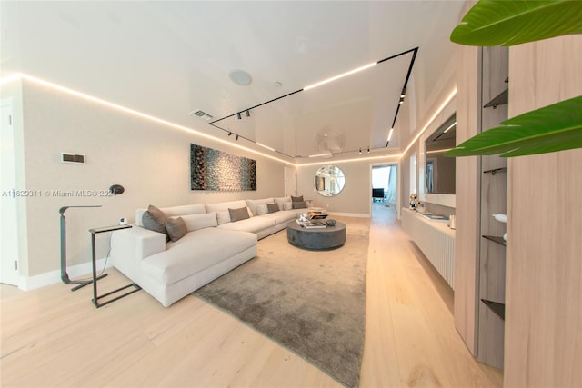 living room with light wood-type flooring and track lighting