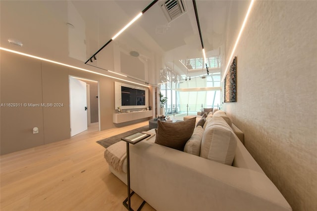 living room with wood-type flooring and a high ceiling