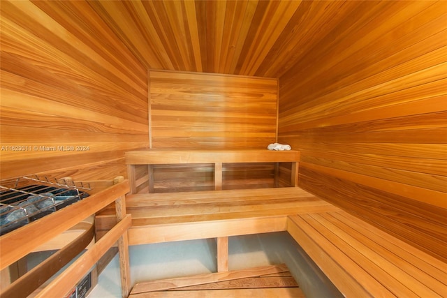 view of sauna featuring wood ceiling and wood walls