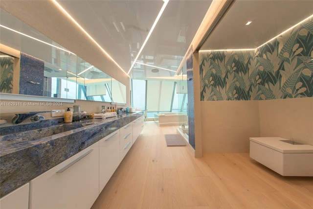 bathroom with wood-type flooring, walk in shower, vanity, and toilet