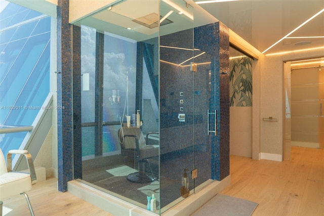 bathroom featuring wood-type flooring and an enclosed shower