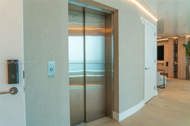 hall featuring light wood-type flooring and elevator