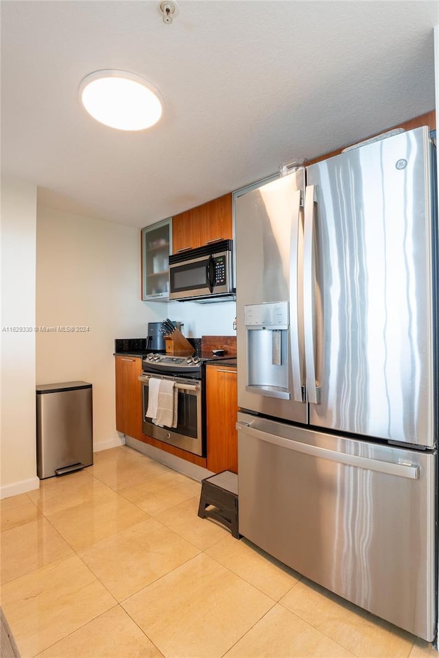 kitchen featuring light tile patterned flooring and appliances with stainless steel finishes